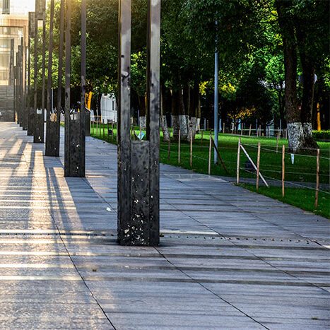 Allée de dalles avec lampadaires et vue d'un parc en arrière plan